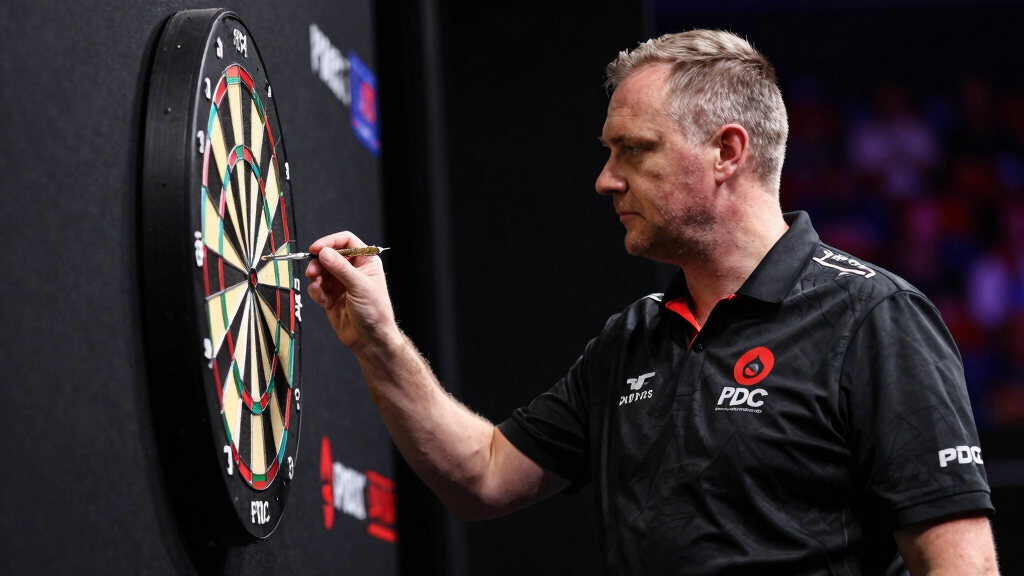 Professional darts player studying the dartboard with intense focus at PDC event